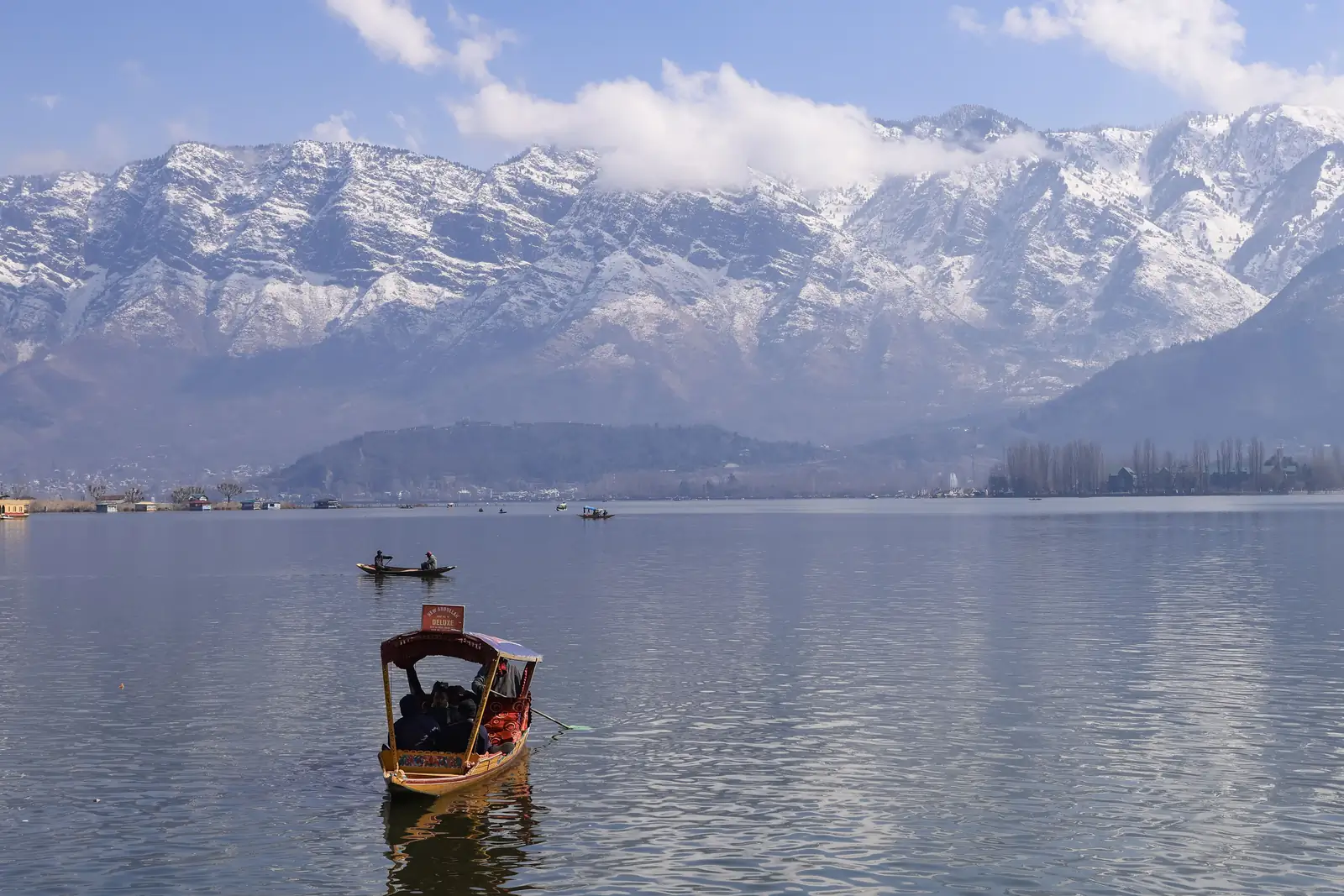 Dal Lake in Srinagar with snow-capped Himalayan peaks on the horizon